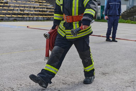 A firefighter dons the essential components of their professional gear, embodying resilience, commitment, and readiness as they gear up for a hazardous firefighting mission, a testament to their unwavering dedication to protecting and saving lives.