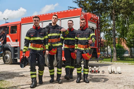 A team of professional firefighters, fully equipped in their gear, stands ready to respond to dangerous situations.