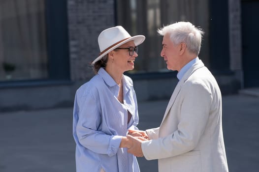 Stylish elderly laughing couple on a walk. Romantic relationships of mature people