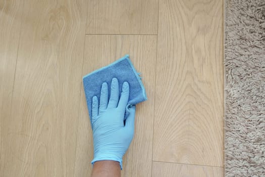 A man's hand washing the floor with a cloth .