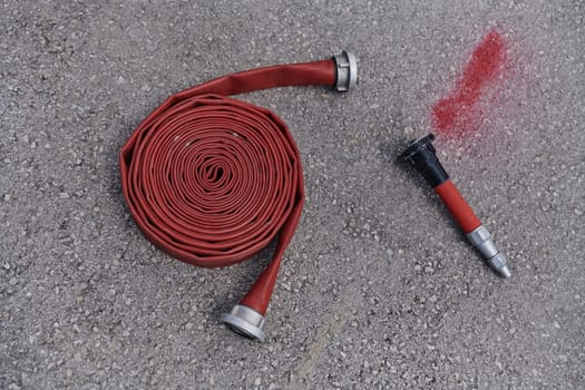 A neatly coiled fire hose lies on the ground, prepared and ready for immediate use in firefighting operations