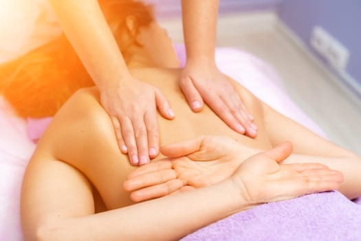 Top view of hands massaging female abdomen.Therapist applying pressure on belly. Woman receiving massage at spa salon.