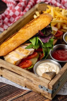 Grilled chicken breast sandwich with french fries and sauces