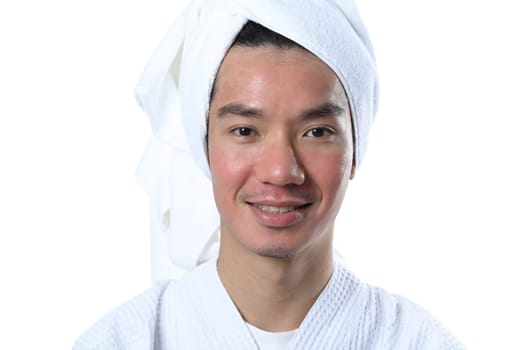 Headshot of handsome young asian man in a bathrobe with skin after laser treatment over white background.