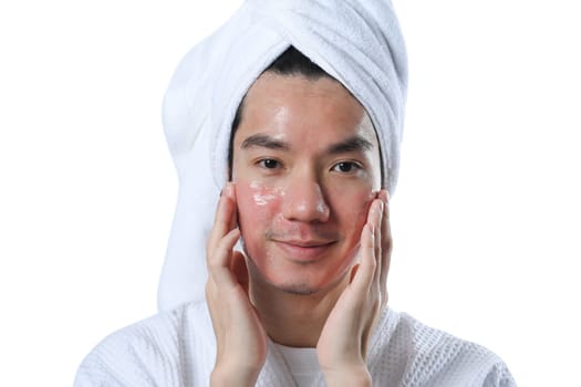 Smiling man taking care of skin for rapid recovery after laser resurfacing, applying moisturizer on his face.