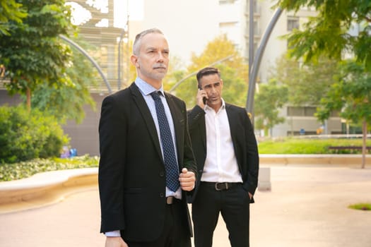 Two trusted business colleagues dressed in formal attire with a mobile phone finishing up the meeting for a business project