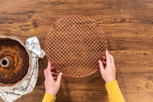 Flat lay. The gingerbread bundt cake cools gracefully on a wire rack, awaiting its sweet caramel frosting.