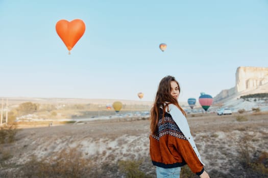 serene woman holding heart balloon in lush field landscape