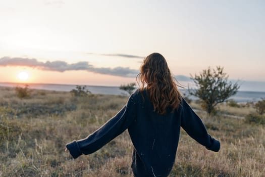 empowered woman embraces the beauty of nature, standing with outstretched arms in a sunsetlit field