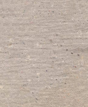 Pressed uneven dense gray cardboard with debris particles