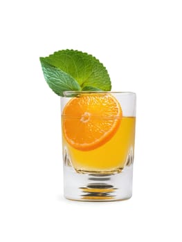 Czech Becherovka in shot glass accompanied by slice of orange and sprig of green mint. Drink isolated on transparent background.