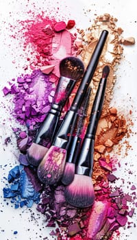 A close-up of makeup brushes covered in various shades of eyeshadow and blush, arranged on a white background.