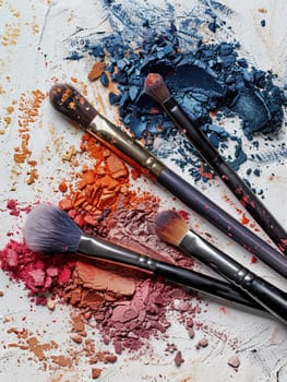 Close-up of makeup brushes with eyeshadow and blush on a white background.