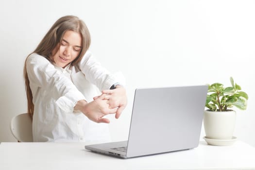 tired girl at the table with a laptop after online classes