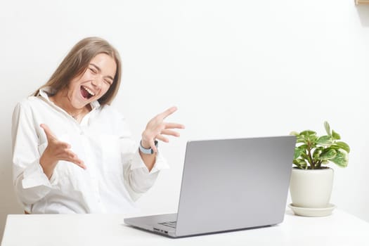 happy girl with a laptop rejoices at a successful job working in the office, successful business, online winning, successful decision