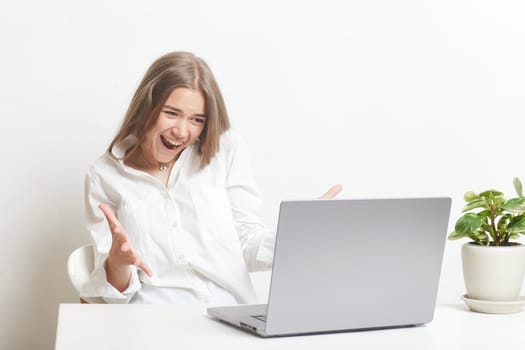 happy girl with a laptop rejoices at a successful job working in the office, successful business, online winning, successful decision