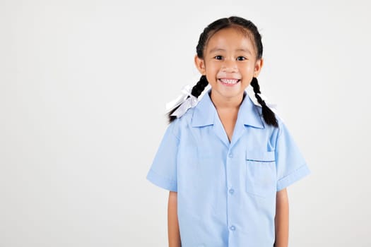 Portrait smiling Asian little girl kindergarten studio shot isolated white background, good job feedback, happy woman kid in pigtails wearing school uniform, back to school concept