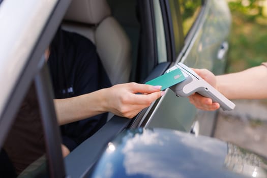 the driver makes contactless NFC payment with a credit card, payment by card for car services, charging an electric car, delivery of online purchases