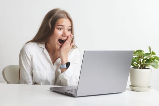 happy girl with a laptop rejoices at a successful job working in the office, successful business, online winning, successful decision