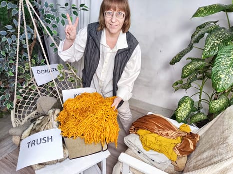 Middle-Aged Woman Sorting Belongings With KonMari Method. Mature woman categorizes items into keep and discard piles