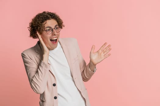 Oh my God, Wow. Excited amazed winner man raising hands in surprise looking at camera with big eyes shocked by sudden victory celebrating success achievement good news. Guy on pink background