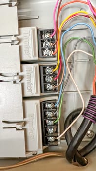 Denver, Colorado, USA-June 2, 2024-Detailed close-up of electrical wiring connections in a control panel. The image highlights various terminals and labeled wires, showing the complexity and precision of electrical installations.