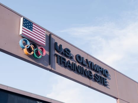 Colorado Springs, Colorado, USA-May 13, 2024-A detailed shot of the entrance sign for the U.S. Olympic Training Site, featuring the American flag and Olympic rings under a clear sky.