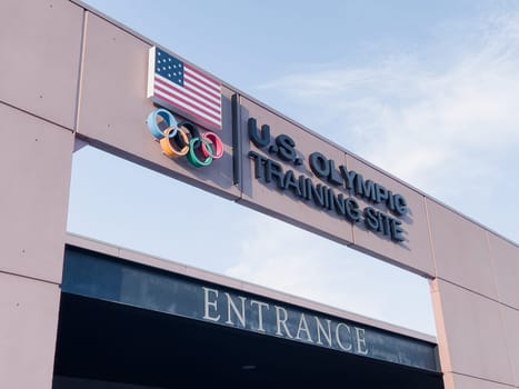 Colorado Springs, Colorado, USA-May 13, 2024-A detailed shot of the entrance sign for the U.S. Olympic Training Site, featuring the American flag and Olympic rings under a clear sky.