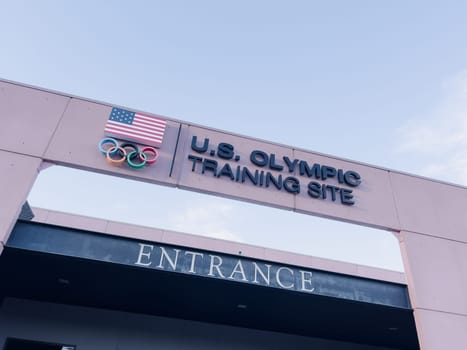 Colorado Springs, Colorado, USA-May 13, 2024-A detailed shot of the entrance sign for the U.S. Olympic Training Site, featuring the American flag and Olympic rings under a clear sky.