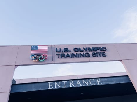 Colorado Springs, Colorado, USA-May 13, 2024-A detailed shot of the entrance sign for the U.S. Olympic Training Site, featuring the American flag and Olympic rings under a clear sky.