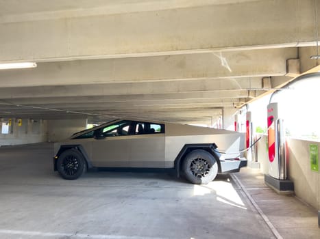 Denver, Colorado, USA-May 31, 2024-A Tesla Cybertruck parked in an indoor charging station, showcasing its futuristic design and rugged build. The setting highlights the vehicles presence in a modern, urban environment.