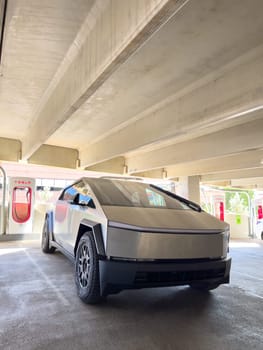 Denver, Colorado, USA-May 31, 2024-A Tesla Cybertruck parked in an indoor charging station, showcasing its futuristic design and rugged build. The setting highlights the vehicles presence in a modern, urban environment.