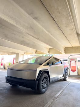Denver, Colorado, USA-May 31, 2024-A Tesla Cybertruck parked in an indoor charging station, showcasing its futuristic design and rugged build. The setting highlights the vehicles presence in a modern, urban environment.