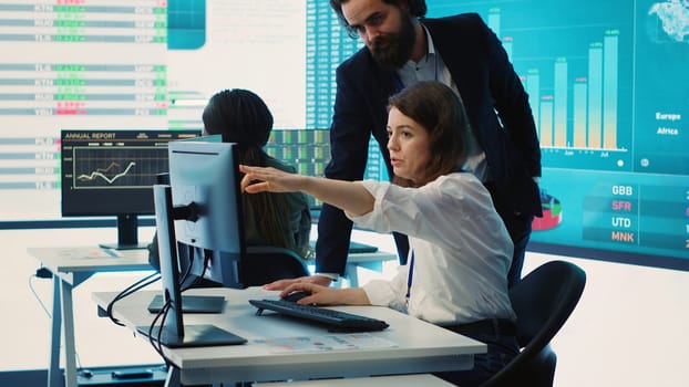 Enterprise colleagues reviewing project updates and details in monitoring room, establishing budget and other resources to achieve strategic business goals. Multiple corporation operations. camera A.