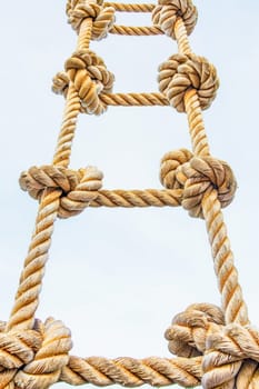 Close up of a rope ladder against a blue sky with keywords such as photograph, rope, accessory, event, and more