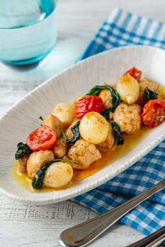 Appetizer with shrimps, onions and tomatoes on a white porcelain plate