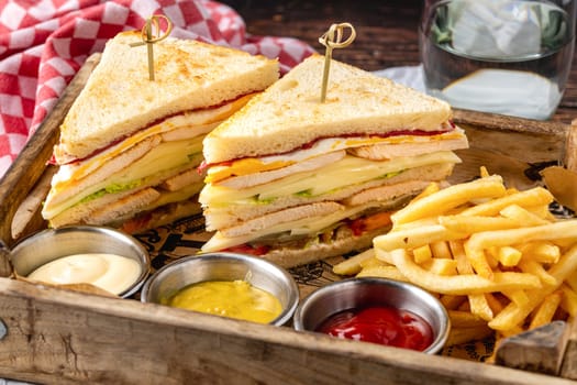 Chicken club sandwich with fries, ketchup, mustard and mayonnaise