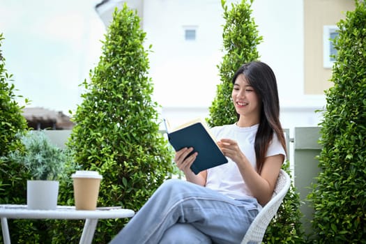 Pretty young woman enjoy relaxing in the garden and reading book.