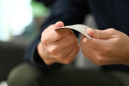 Cropped shot of upset young man breaking his credit card. Financial problems concept.