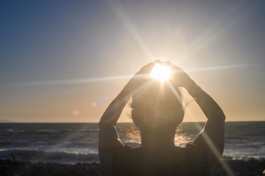 Silhouette of a woman holding the sun in her hands 2