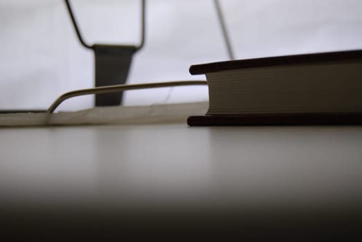 There is a book on the table and a book stand in the background.