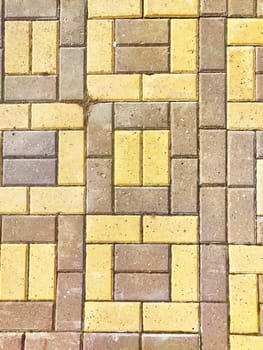 Bricks are like tiles on a path or sidewalk. Background, texture. A decorative brick path leads past a row of parked cars