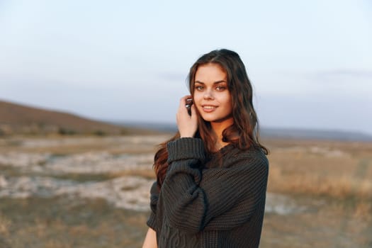 Confident young woman posing in a vast field with a selfassured expression and hands on her head