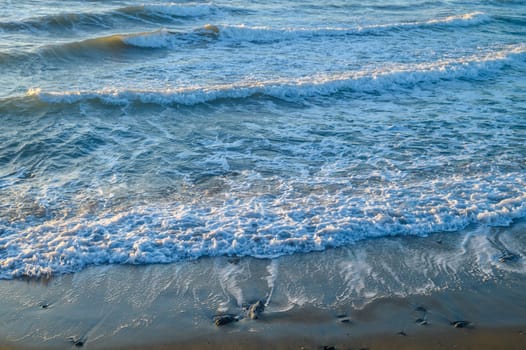 waves and sea foam in the Mediterranean Sea in Cyprus at sunset