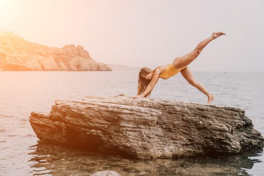 Woman meditating in yoga pose silhouette at the ocean, beach and rock mountains. Motivation and inspirational fit and exercising. Healthy lifestyle outdoors in nature, fitness concept.