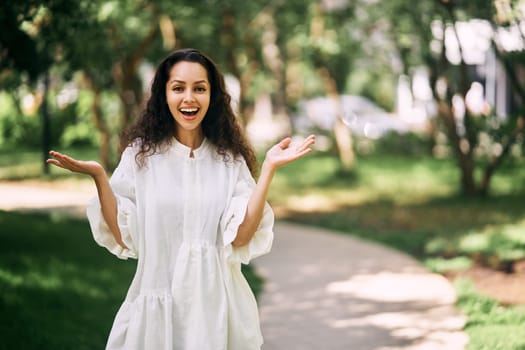 Admiring curly-haired brunette girl with raised hands. High quality photo