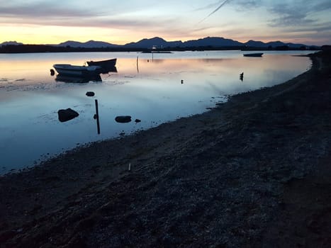 Sunset over a bay with boats on a summer evening in Italy.