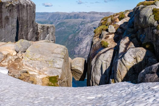 A close-up view of the famous balancing rock at Kjeragbolten, Norway. The rock appears to be precariously perched between two cliffs, creating a sense of awe and wonder. Kjeragbolten, Norway