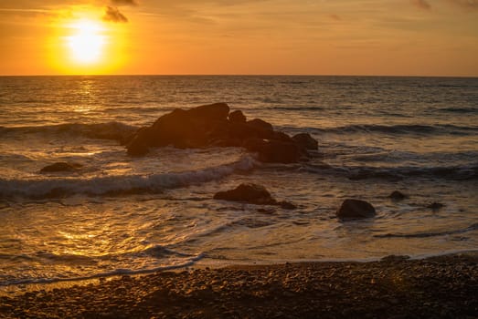 sunset on the sea - A sea wave breaks on a large stone with beautiful white splashes. 3