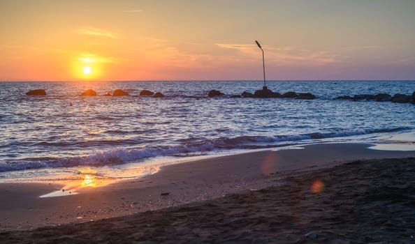 Sunset on pebble beach with sea waves of mediterranean sea 2